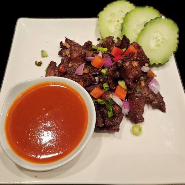 Erawan's Thai dish of crispy fried beef with red sauce, red onions, bell peppers, and cucumbers.