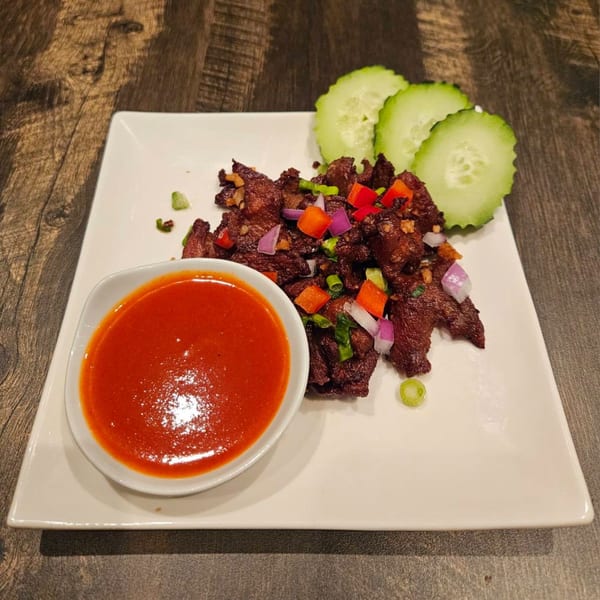 Erawan's Thai beef jerky with chili sauce, red onions, bell peppers, and cucumber slices.