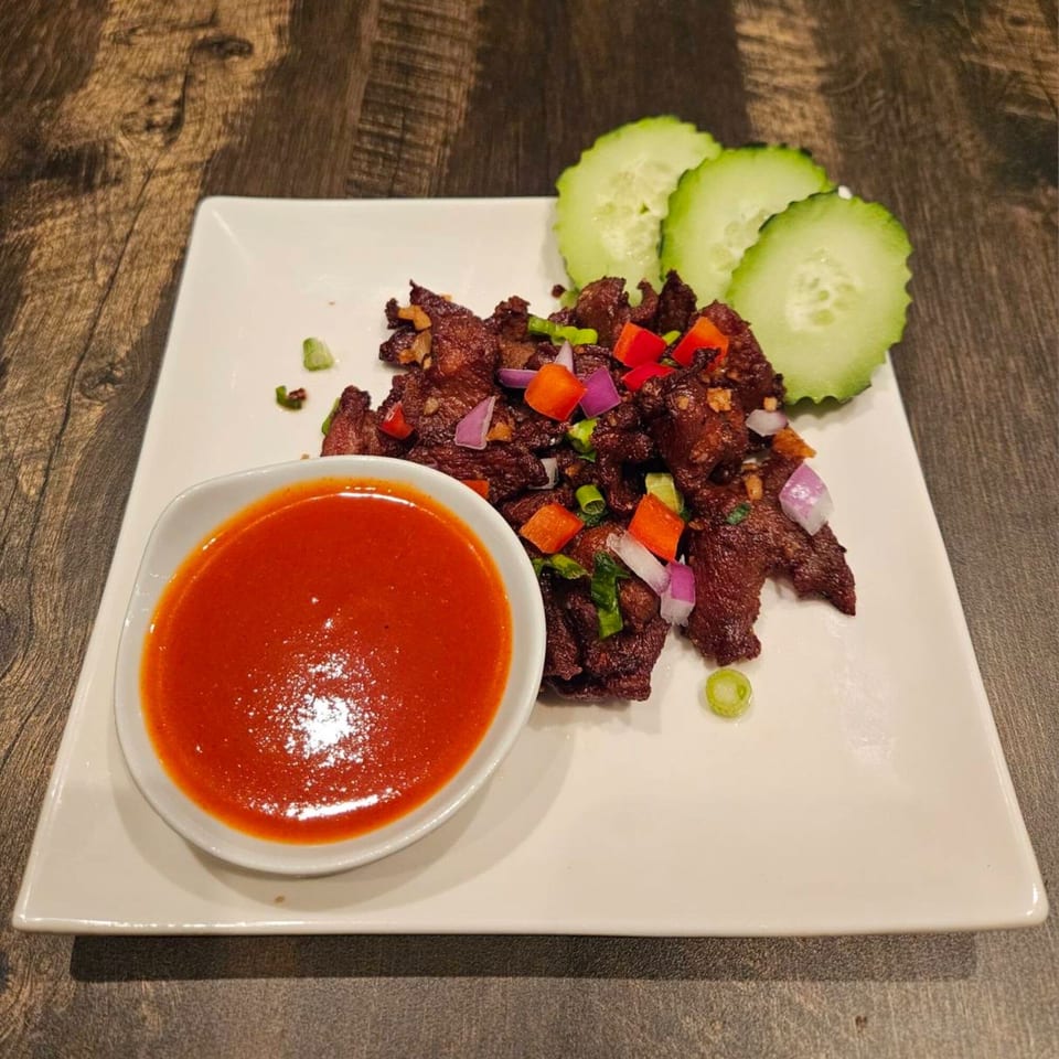 Erawan's Thai beef jerky with chili sauce, red onions, bell peppers, and cucumber slices.