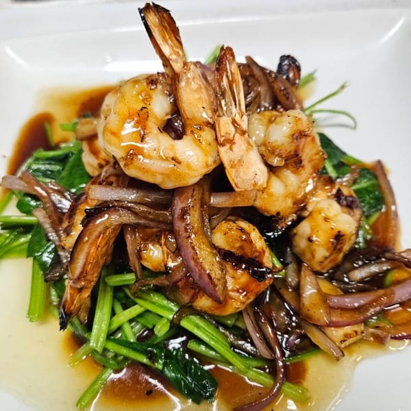 Erawan's Thai dish with grilled shrimp, caramelized onions, and green vegetables in a savory sauce.