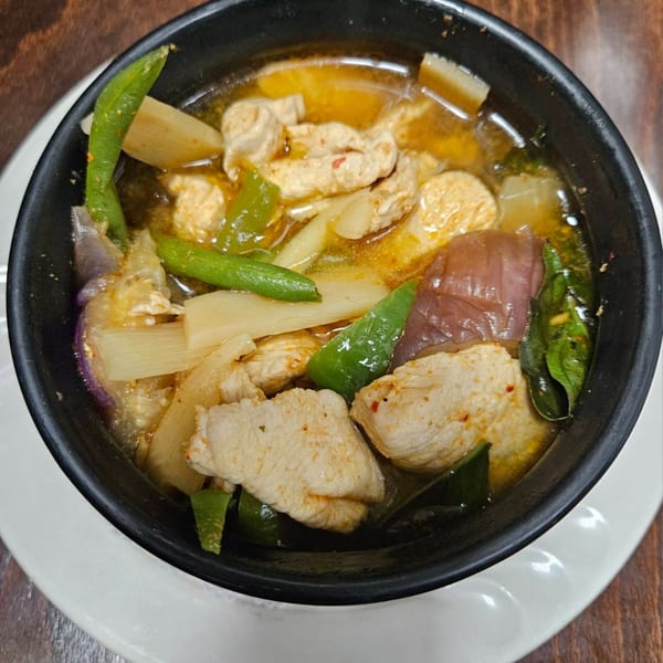 Close-up of Erawan's Thai chicken soup with green beans, eggplant, and bamboo shoots.