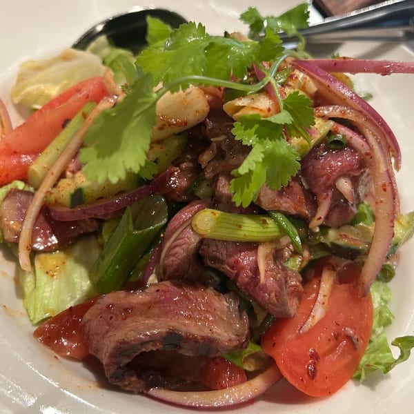 Erawan's Thai beef salad with red onions, tomatoes, green onions, and cilantro.