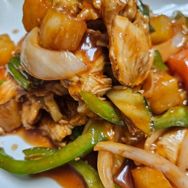 Close-up of Erawan's sweet and sour chicken with pineapple, bell peppers, and onions.