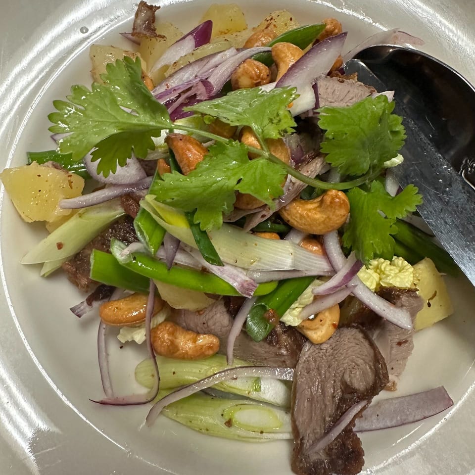 Close-up of Erawan's Thai salad with beef, cashews, red onion, green onion, pineapple, and cilantro.